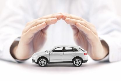 Foto: Hände über kleinem Auto